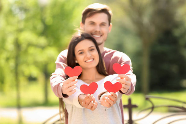 Портрет прекрасной пары с бумажными сердцами на открытом воздухе
 - Фото, изображение
