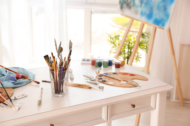 Ensemble d'outils avec peintures sur table dans l'atelier de l'artiste
 - Photo, image