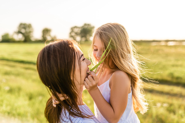 lähikuva muotokuva äiti ja tytär hauskaa yhdessä vihreä niitty
 - Valokuva, kuva