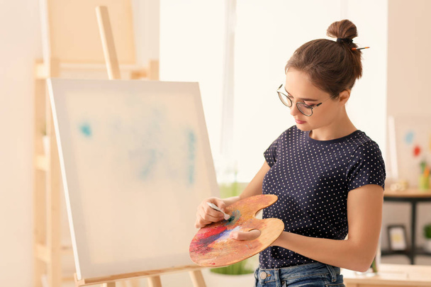Artista femenina con paleta y pintura en taller
 - Foto, Imagen