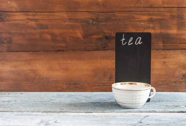 filiżanka Biała herbata i mała tablica na drewnianym blatem. W menu. Karta herbaty. Karta kawowa - Zdjęcie, obraz
