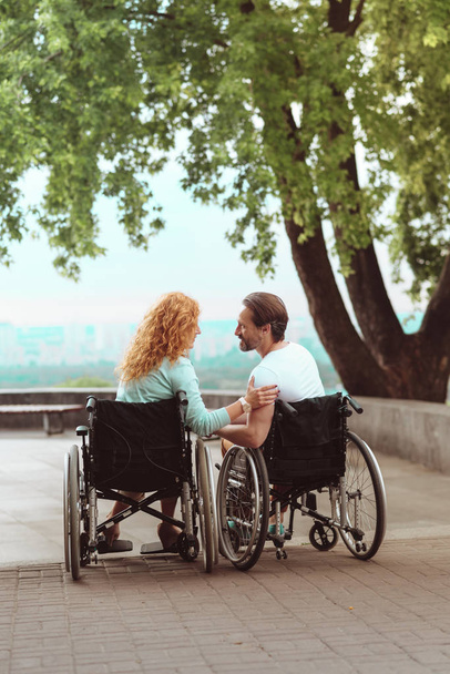 Adorable disabled couple chatting outdoors - Φωτογραφία, εικόνα