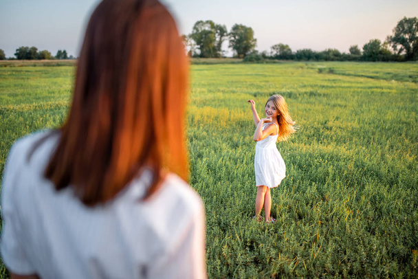 mother and happy daughter spending time time together in green meadow - Foto, Imagem