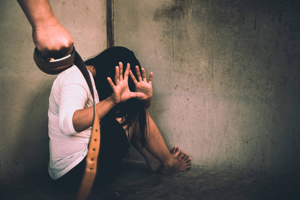 Frau Opfer häuslicher Gewalt und Missbrauch. Ehemann schüchtert seine Frau ein der Arm mit dem Gürtel - Foto, Bild