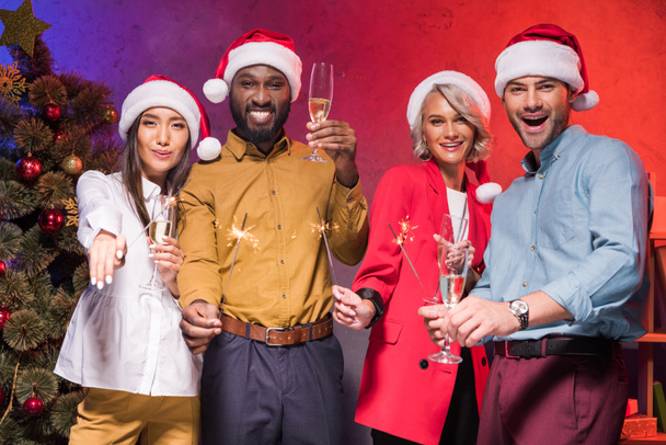 empresários multiétnicos segurando espumantes de Natal e copos de champanhe na festa corporativa de ano novo
 - Foto, Imagem