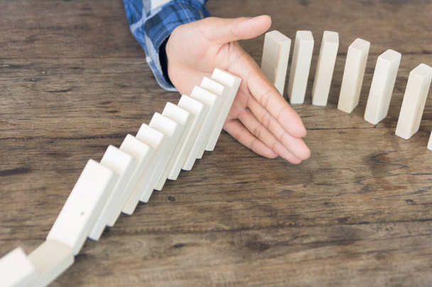 Hand stopping domino effect of wooden blocks for concept about business and accountability. - Foto, Imagem
