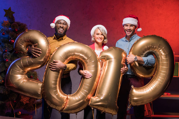 щасливі мультикультурному бізнесмени тримає повітряні кульки 2019 на новорічний корпоратив - Фото, зображення