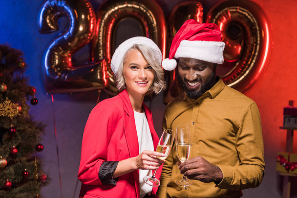 smiling african american businessman and caucasian businesswoman at new year corporate party - Fotó, kép
