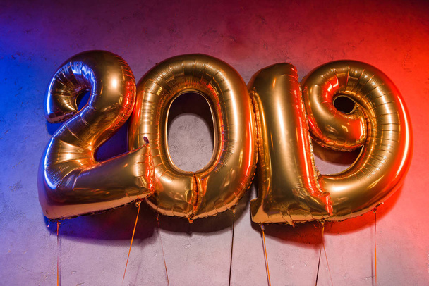 golden 2019 sign balloons with blue and red light on grey - Fotografie, Obrázek