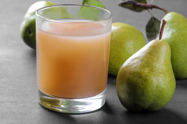 Succo di pera in un bicchiere e pere mature fresche su un tavolo nero. primo piano
 - Foto, immagini