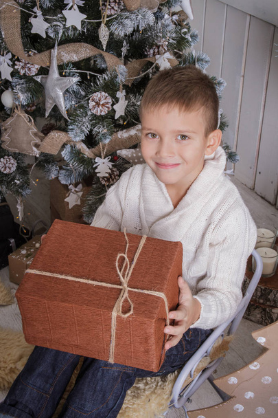 Smiling boy with Christmas gift on sleigh - Fotoğraf, Görsel