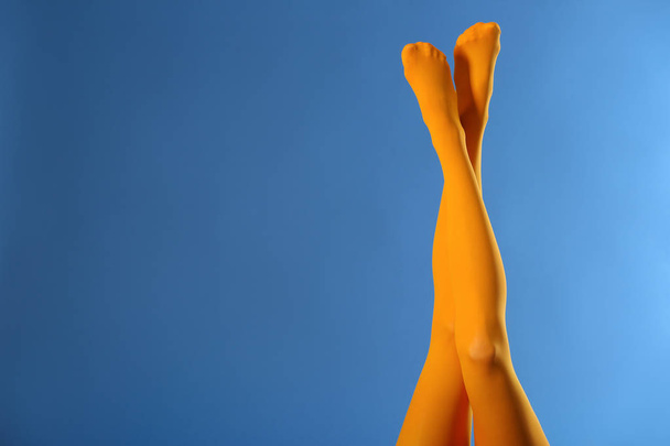 Beine der schönen jungen Frau in Strumpfhosen auf farbigem Hintergrund - Foto, Bild