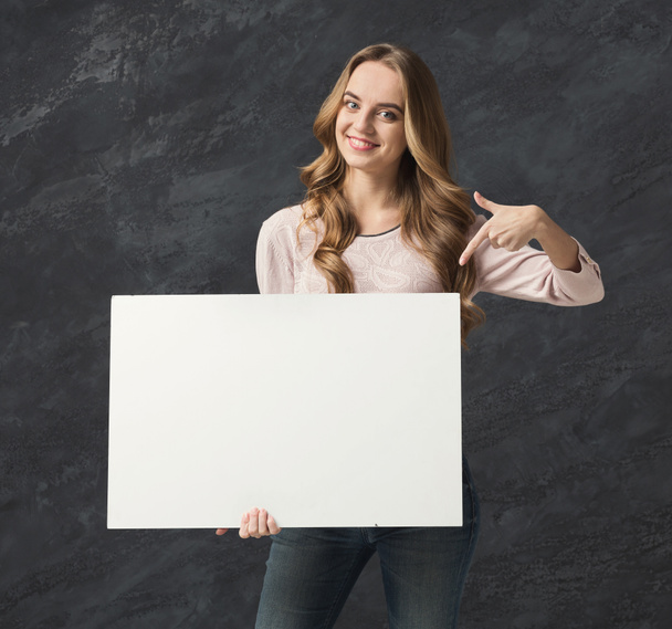 Młoda kobieta uśmiechający się z biała kartka papieru - Zdjęcie, obraz