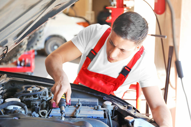Jeune mécanicien automobile réparation de voiture dans le centre de service
 - Photo, image