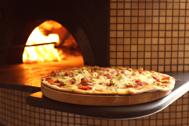 Ízletes pizza a fedélzeten közelében tűzifa ler vagy grill - Fotó, kép