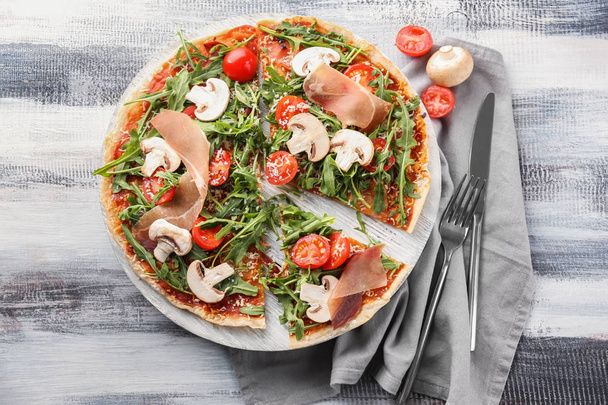 Placa de madeira com pizza saborosa na mesa
 - Foto, Imagem