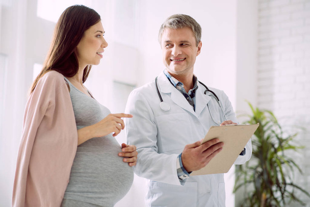 Happy pregnant woman talking to her doctor - Zdjęcie, obraz
