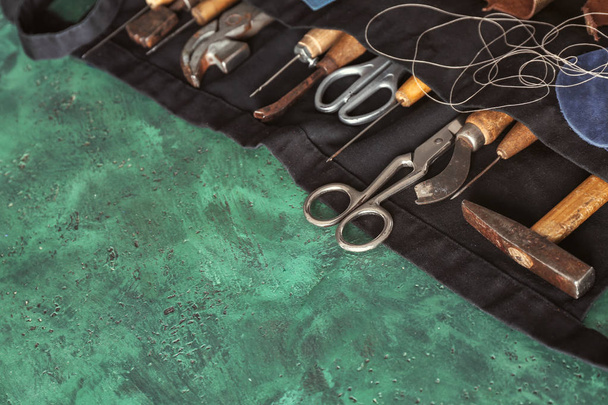 Tablier avec outils artisanaux sur table en atelier de cuir
 - Photo, image