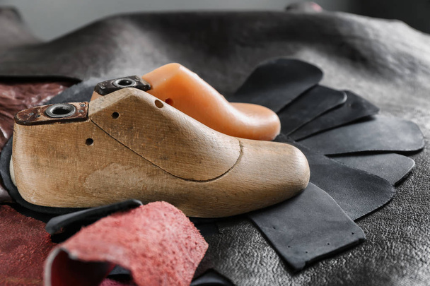 Plastic and wooden shoe-trees with leather in workshop - Photo, Image
