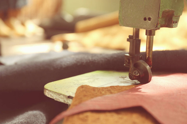 Швейная машина с кожей на столе, крупным планом
 - Фото, изображение