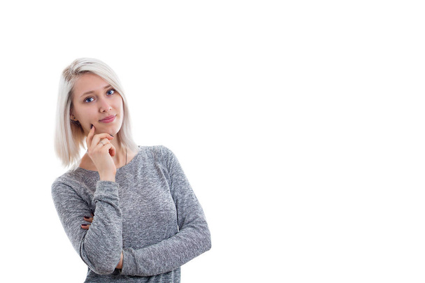 Πορτρέτο του ένα συλλογισμένος νεαρή γυναίκα με ξανθά μαλλιά στέκεται απομονωθεί σε λευκό φόντο. - Φωτογραφία, εικόνα