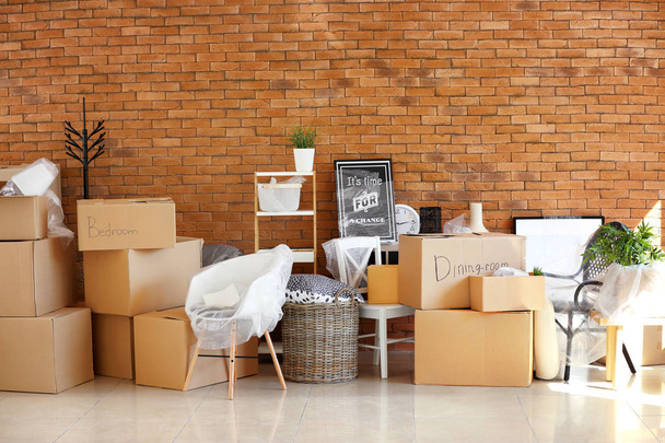 Carton boxes and interior items in room. Moving house concept - Photo, Image