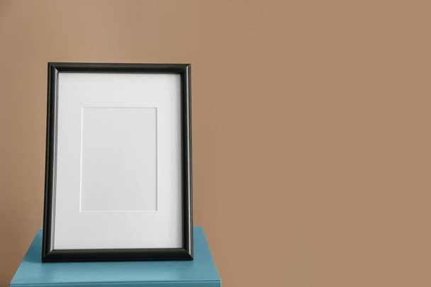 Photo frame on stand against color background - Photo, Image