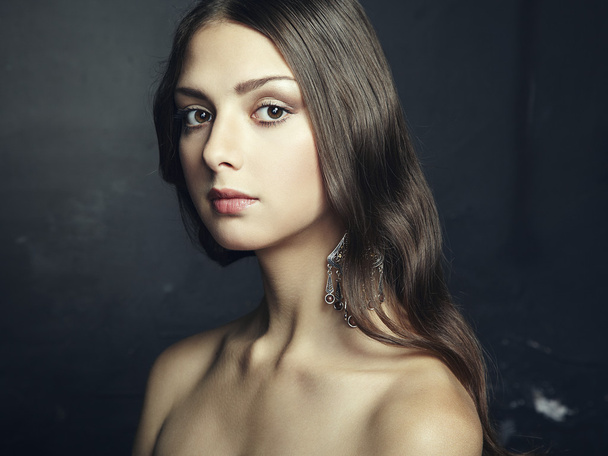 Portrait of beautiful young woman with earring - Foto, Imagem