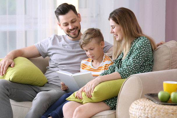 Ευτυχισμένη οικογένεια στην ανάγνωση του βιβλίου μαζί στο σπίτι - Φωτογραφία, εικόνα