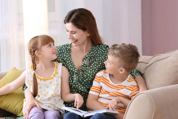 Μητέρα και τα παιδιά που διαβάζοντας το βιβλίο μαζί στο σπίτι - Φωτογραφία, εικόνα