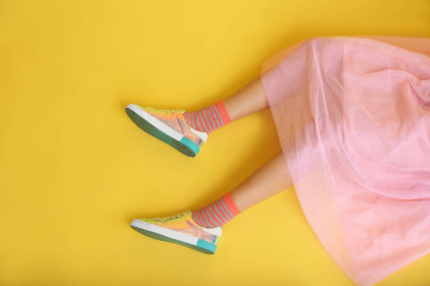 Ноги красивої молодої жінки на кольоровому фоні
 - Фото, зображення