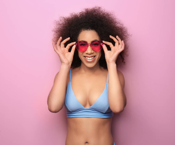 Красива афро-американських жінка в бікіні і з сонцезахисні окуляри на колір тла - Фото, зображення