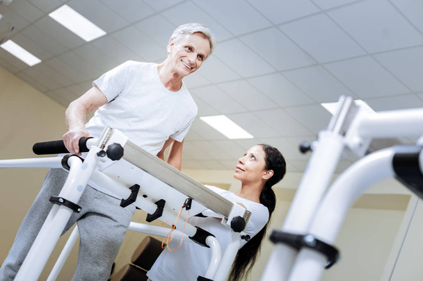 Emotional senior man feeling excited while being in a modern gym - Photo, Image