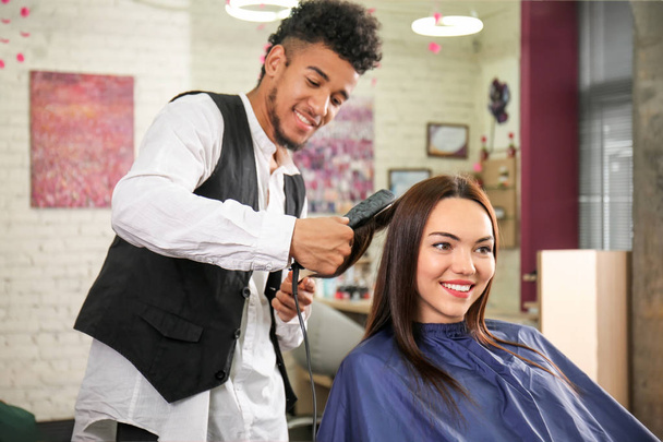 Профессиональный парикмахер работает с клиентом в салоне красоты
 - Фото, изображение