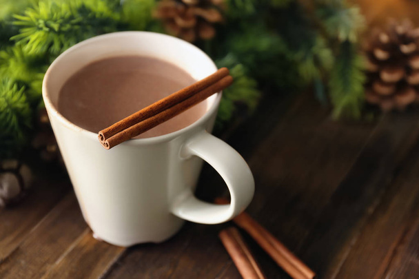 Чашка гарячого какао з паличками кориці на дерев'яному столі
 - Фото, зображення