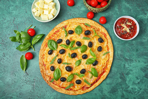 leckere Pizza mit Oliven und Zutaten auf farbigem Hintergrund - Foto, Bild