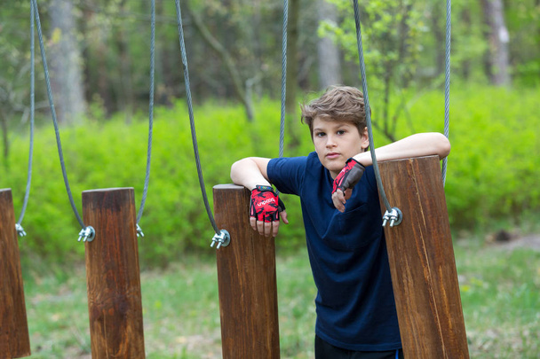 jeune garçon mignon sportif est venu au parc de corde d'aventure pour s'amuser sur ses vacances d'été ou de printemps
 - Photo, image