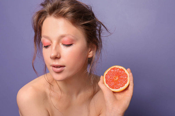 Красива молода жінка з грейпфрутом на кольоровому фоні
 - Фото, зображення