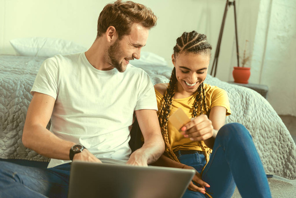 Radiant couple laughing while making online shopping - Φωτογραφία, εικόνα