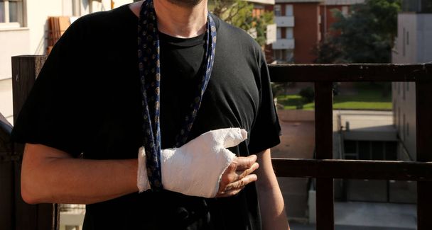 мужчина после аварии с рукой на шее и рукой, сломанной гипсом, чтобы обездвижить конечность
 - Фото, изображение