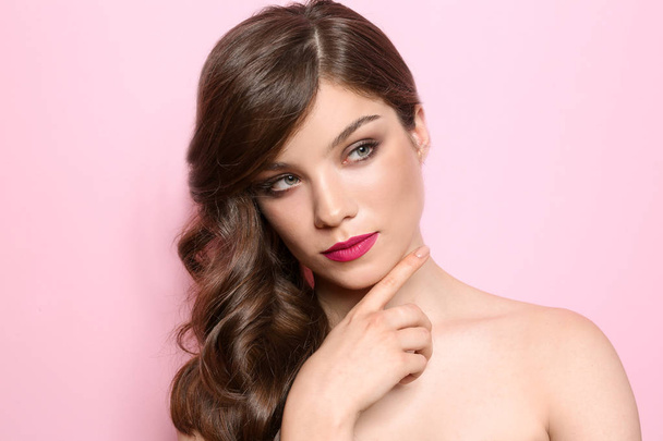 Portrait of young woman with professional makeup on color background - Photo, Image
