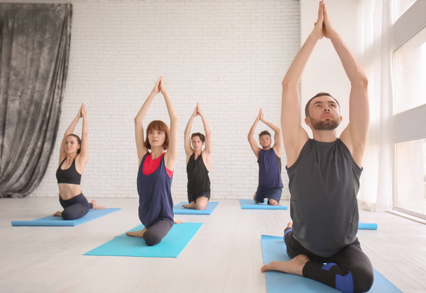 Grupo de deportistas practicando yoga en interiores
 - Foto, Imagen