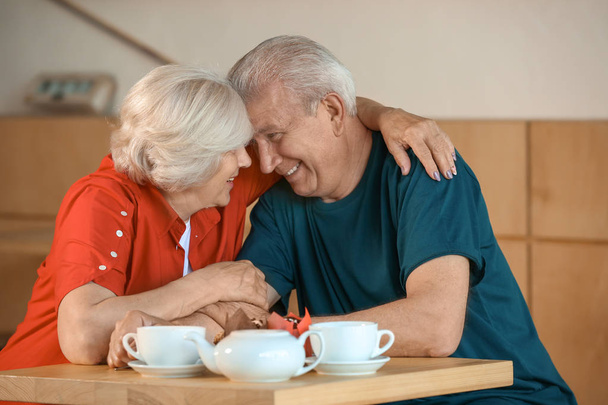 Onnellinen vanhempi pari istuu yhdessä kahvilassa
 - Valokuva, kuva