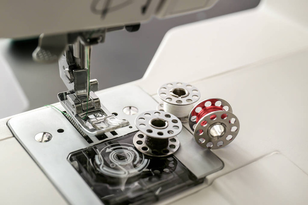 Presionador de pie y aguja de la moderna máquina de coser con carretes, primer plano
 - Foto, imagen