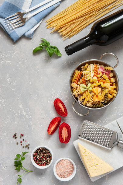 Ingredients for traditional pasta cooking with cheese, tomatoes, condiments on light concrete background. Top view - Foto, Imagen