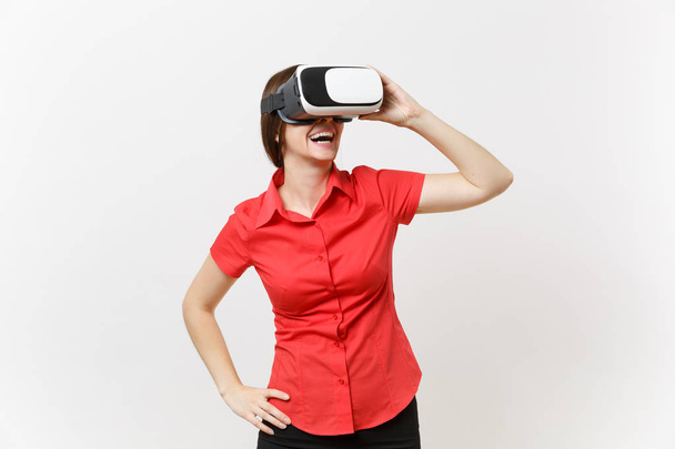 Portrait of young smart business woman in red shirt, black skirt in headset of virtual reality on head isolated on white background. Education or teaching of future in high school university concept - Photo, Image