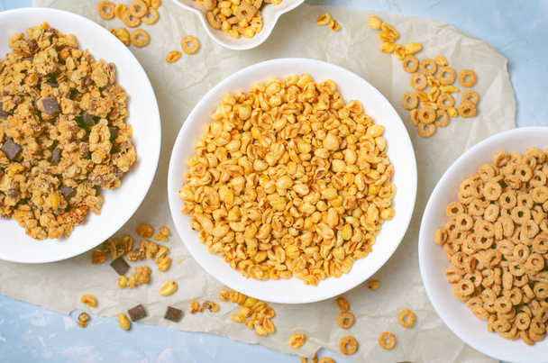 Diversi tipi di cereali, colazione veloce, spuntini sani, riso soffiato, anelli di cereali e cioccolato Granola
 - Foto, immagini