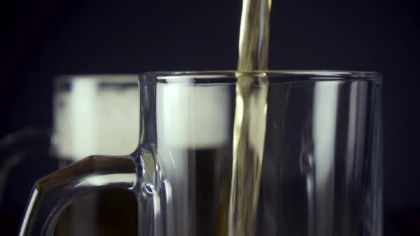 Slow motion pour light beer in a mug on a grey background close-up - Materiał filmowy, wideo