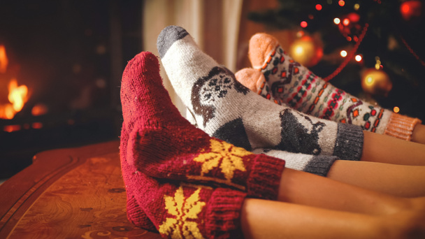 Photo tonique de famille dans des chaussettes de laine couchées à côté de la cheminée en feu dans le salon
 - Photo, image