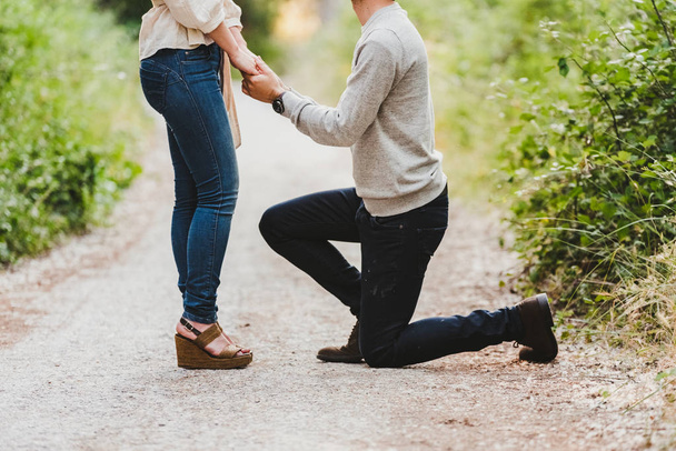 man proposing marriage to his girlfriend in the field - Photo, Image